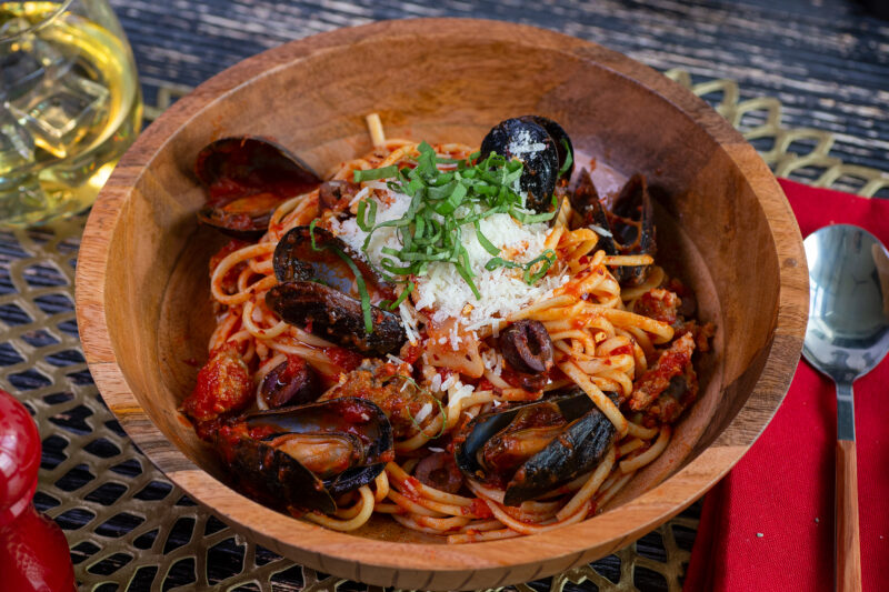 A wooden bowl of Spicy Pasta Alla Diavola with Mussels